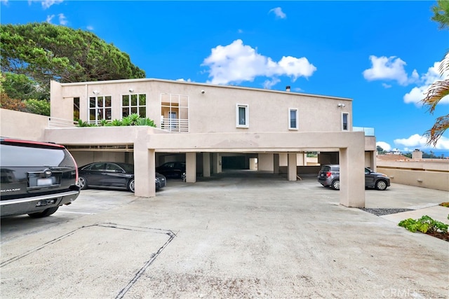 view of front of home featuring covered parking and stucco siding