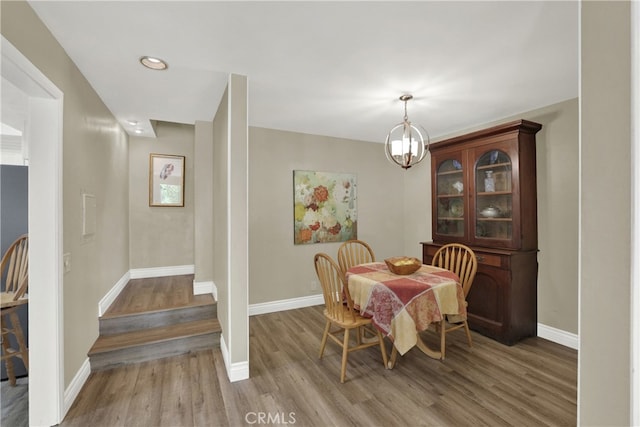 dining area featuring a notable chandelier, baseboards, wood finished floors, and recessed lighting