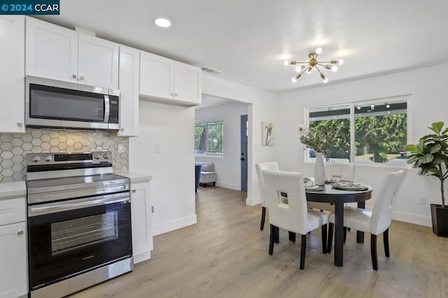 dining space featuring light wood-type flooring and a chandelier