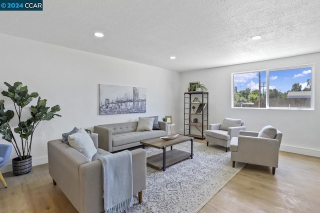 living room featuring a textured ceiling and light wood-type flooring