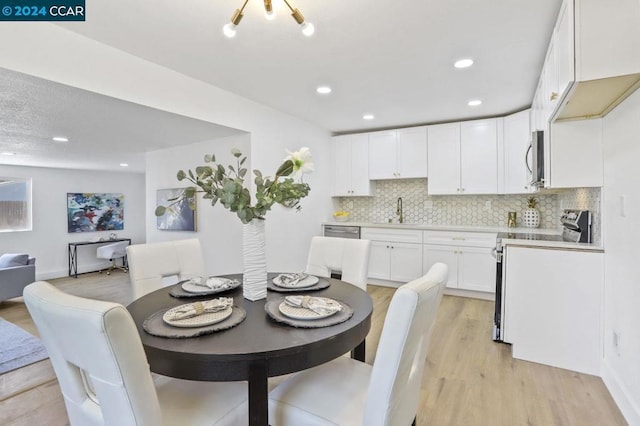 dining area featuring sink and light wood-type flooring