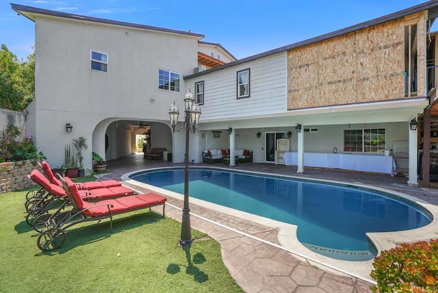 view of pool with a patio area and a yard