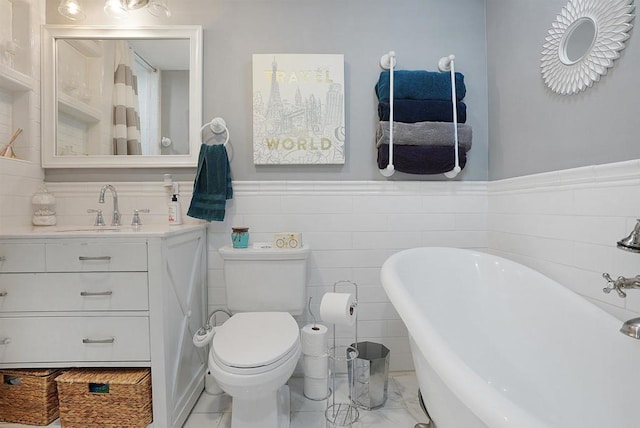 bathroom featuring a bath, toilet, vanity, tile walls, and tile patterned floors