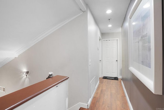 hall featuring ornamental molding and light hardwood / wood-style flooring