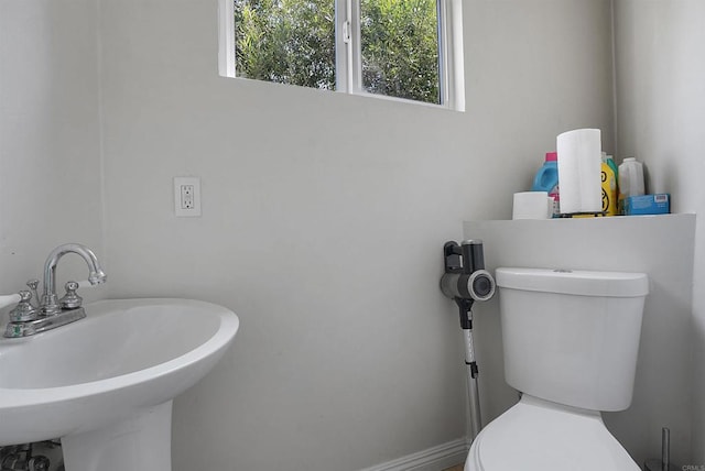 bathroom featuring a wealth of natural light, sink, and toilet