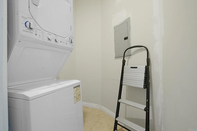 laundry area featuring light tile patterned flooring, stacked washing maching and dryer, and electric panel