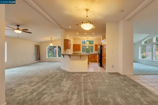 kitchen with a kitchen bar, a wealth of natural light, vaulted ceiling, and ceiling fan