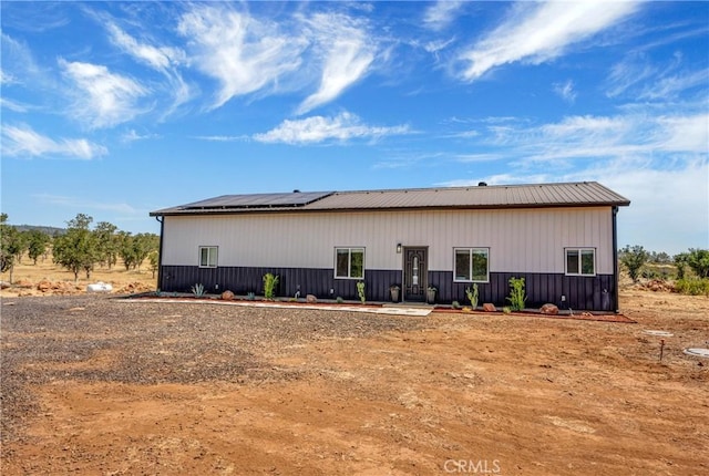 back of property featuring solar panels