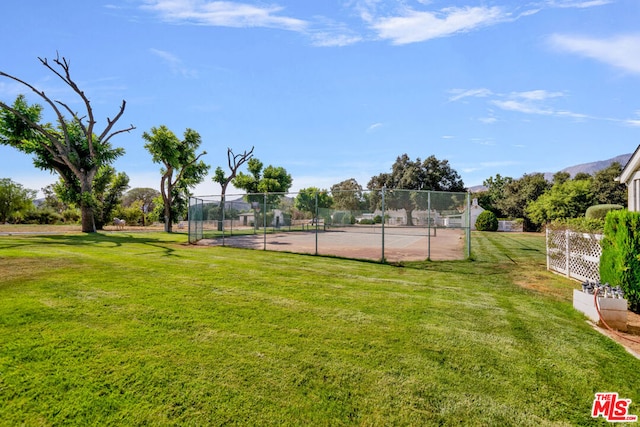 view of basketball court with a yard and tennis court