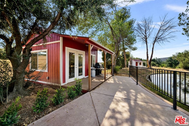 view of side of home featuring french doors and a water view