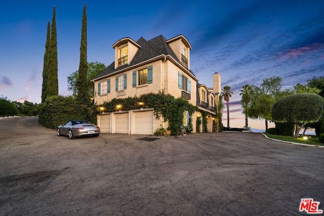 property exterior at dusk featuring a garage