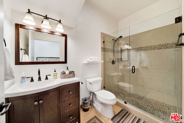 bathroom featuring vanity, tile patterned flooring, toilet, and walk in shower