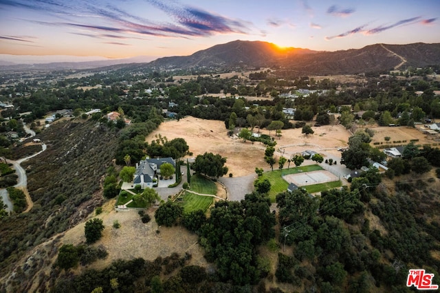 aerial view at dusk featuring a mountain view