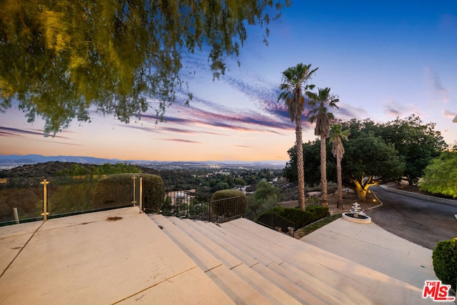 patio terrace at dusk featuring a mountain view