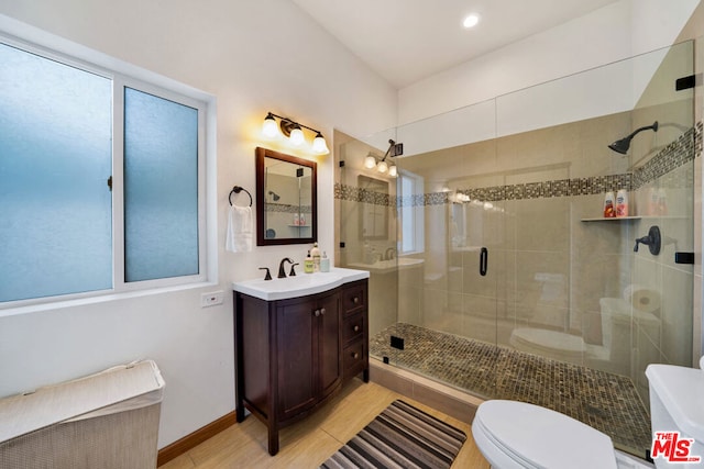 bathroom with vanity, tile patterned flooring, toilet, and an enclosed shower