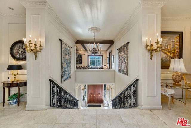 tiled entrance foyer with a notable chandelier and crown molding