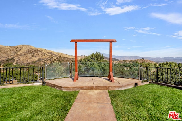 surrounding community with a mountain view and a lawn