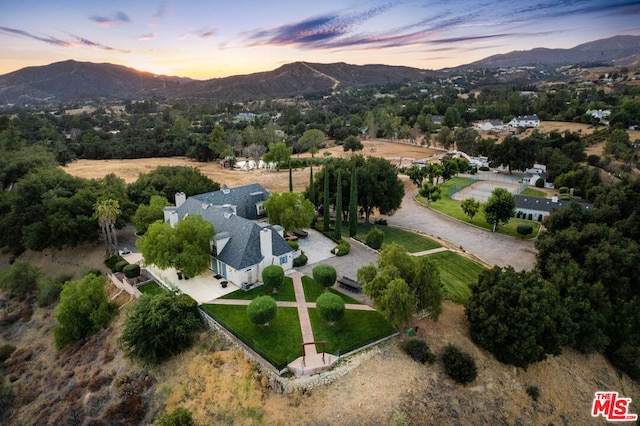 aerial view at dusk featuring a mountain view