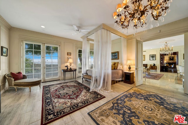 entrance foyer featuring ornamental molding, ceiling fan with notable chandelier, and hardwood / wood-style floors