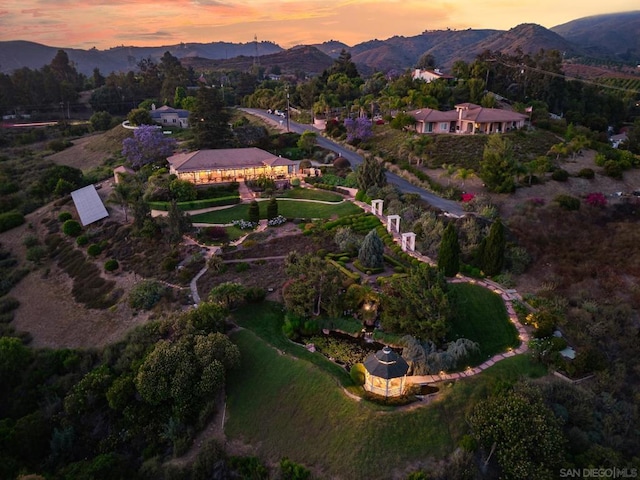 aerial view at dusk featuring a mountain view