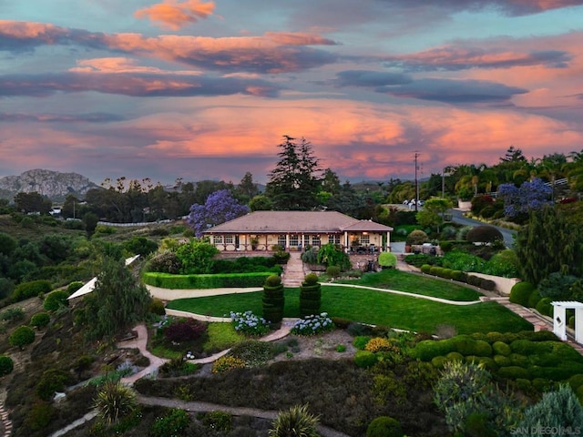 view of home's community with a mountain view and a lawn