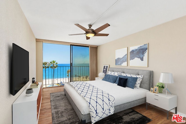 bedroom featuring ceiling fan, access to outside, floor to ceiling windows, and wood-type flooring