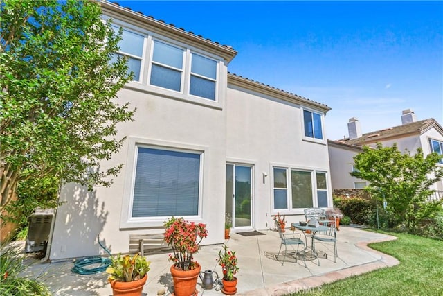 rear view of property with a patio area, stucco siding, and fence