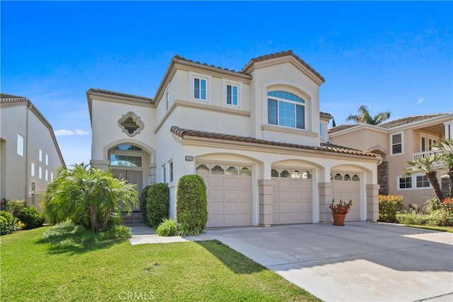 mediterranean / spanish home with a garage, concrete driveway, stucco siding, and a tiled roof