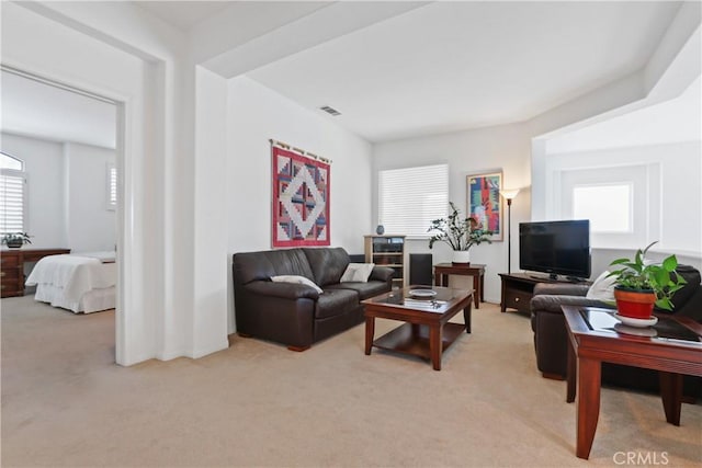 living area featuring light carpet and visible vents