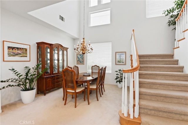 dining room with visible vents, light carpet, an inviting chandelier, and stairway