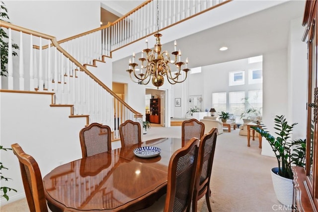 dining room with stairway, a notable chandelier, a towering ceiling, and carpet flooring