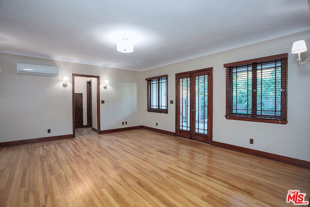 spare room with light hardwood / wood-style flooring and a wall mounted air conditioner