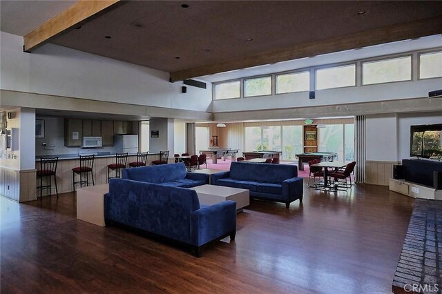 3601 W Hidden Ln Unit 121, Rolling Hills Estates, CA 90274 - living room featuring dark wood-style flooring, a towering ceiling, beam ceiling, healthy amount of natural light, and a wainscoted wall
