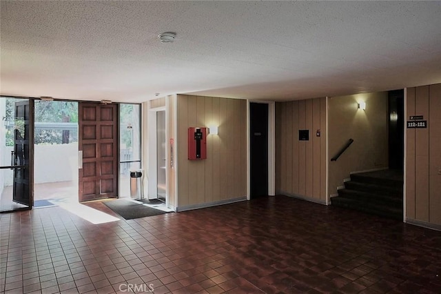 3601 W Hidden Ln Unit 121, Rolling Hills Estates, CA 90274 - empty room with a smoke detector, a textured ceiling, stairway, and wooden walls