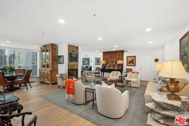 living room featuring a large fireplace and light hardwood / wood-style floors