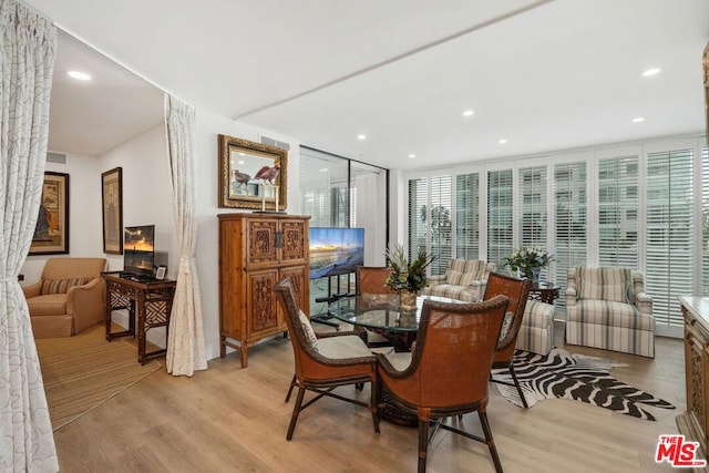 dining room featuring expansive windows and light hardwood / wood-style floors