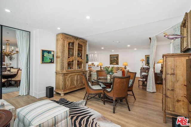 dining area featuring light hardwood / wood-style floors and a chandelier