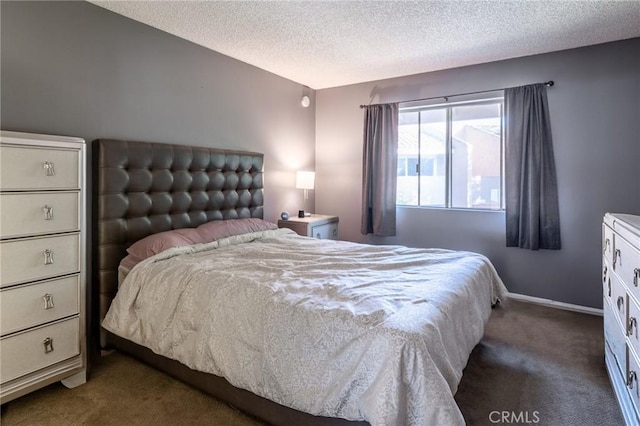 bedroom featuring a textured ceiling and dark carpet