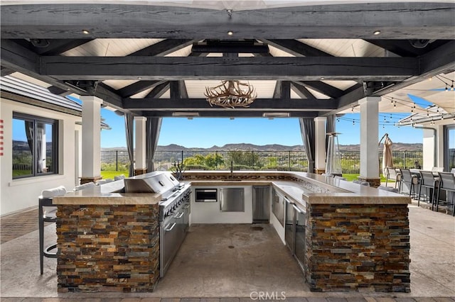 view of patio / terrace featuring a gazebo, area for grilling, a mountain view, and fence