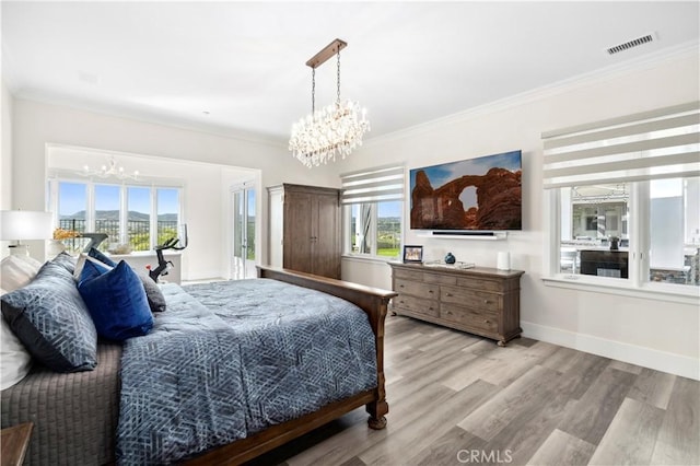 bedroom with a notable chandelier, visible vents, ornamental molding, and wood finished floors