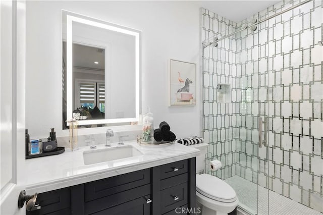 bathroom featuring vanity, toilet, and a stall shower