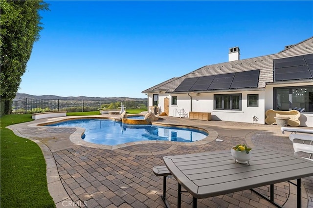 view of pool featuring a fenced in pool, fence, an in ground hot tub, a patio area, and a mountain view