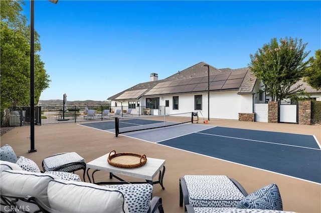 view of sport court with an outdoor living space and fence