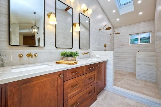 bathroom featuring vanity, a skylight, tile walls, and a tile shower