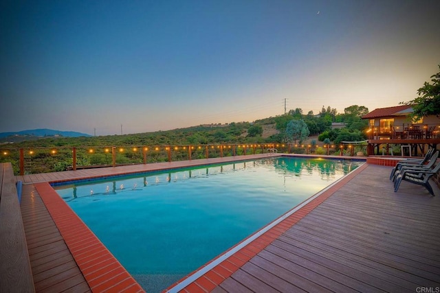 pool at dusk featuring a mountain view