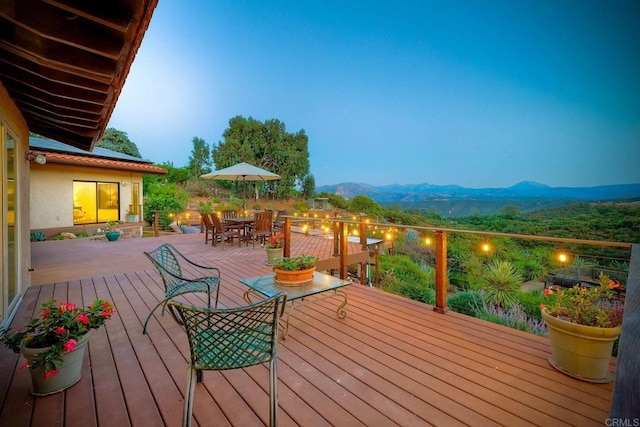 deck at dusk featuring a mountain view