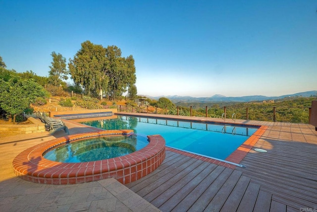 view of pool featuring a mountain view and an in ground hot tub