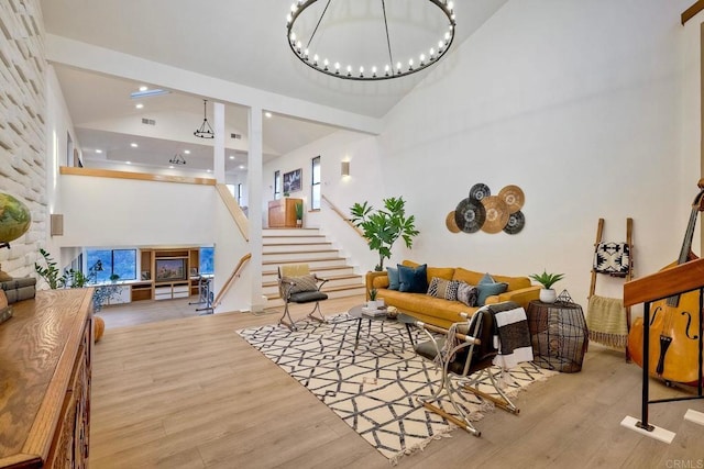 interior space with high vaulted ceiling, a notable chandelier, and light hardwood / wood-style flooring