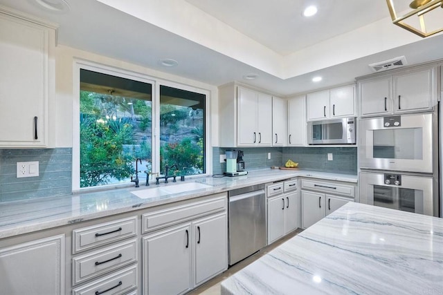 kitchen with light stone counters, sink, stainless steel appliances, and tasteful backsplash