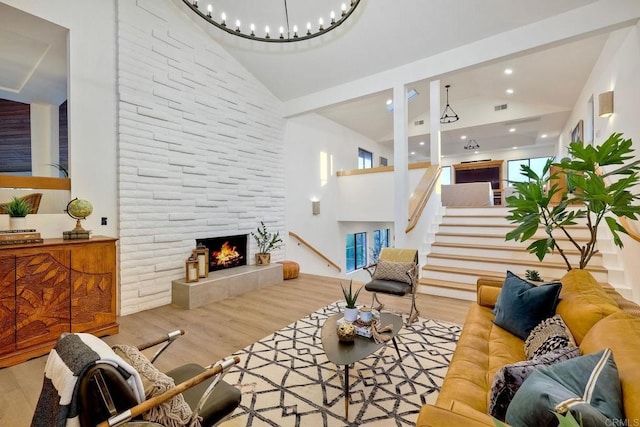 living room with light hardwood / wood-style floors, high vaulted ceiling, and a fireplace